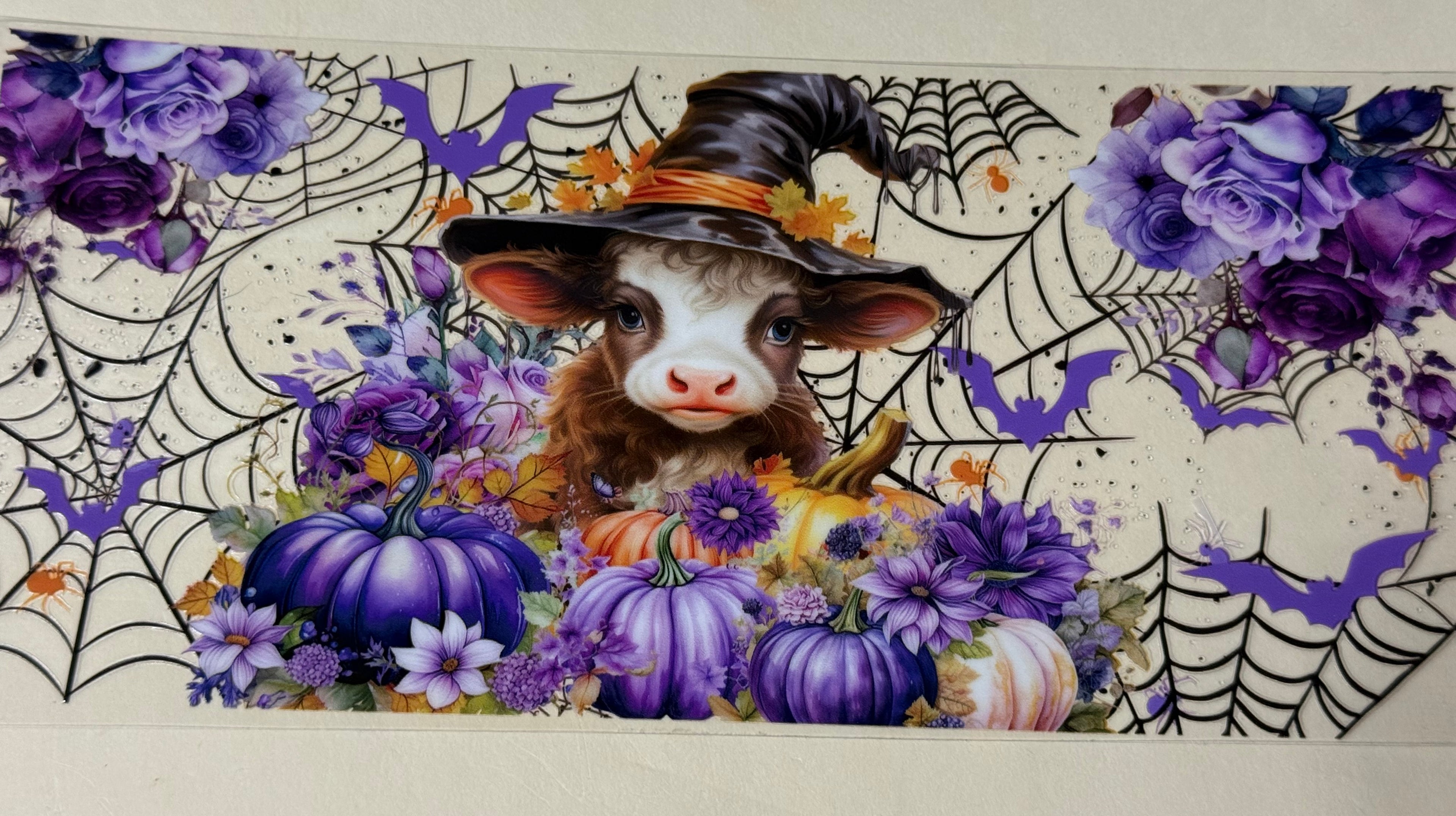 cow with purple pumpkins and a which hat